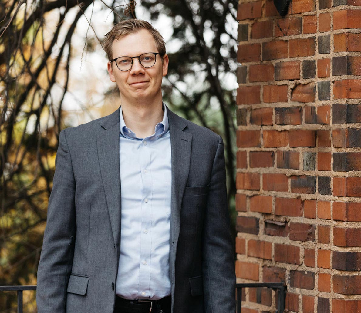 Dr. Tyler Gerdin, executive coach and founder of Mountain North Coaching and Consulting in Spokane, leaning against a brick wall, representing his expertise in leadership development and executive coaching.